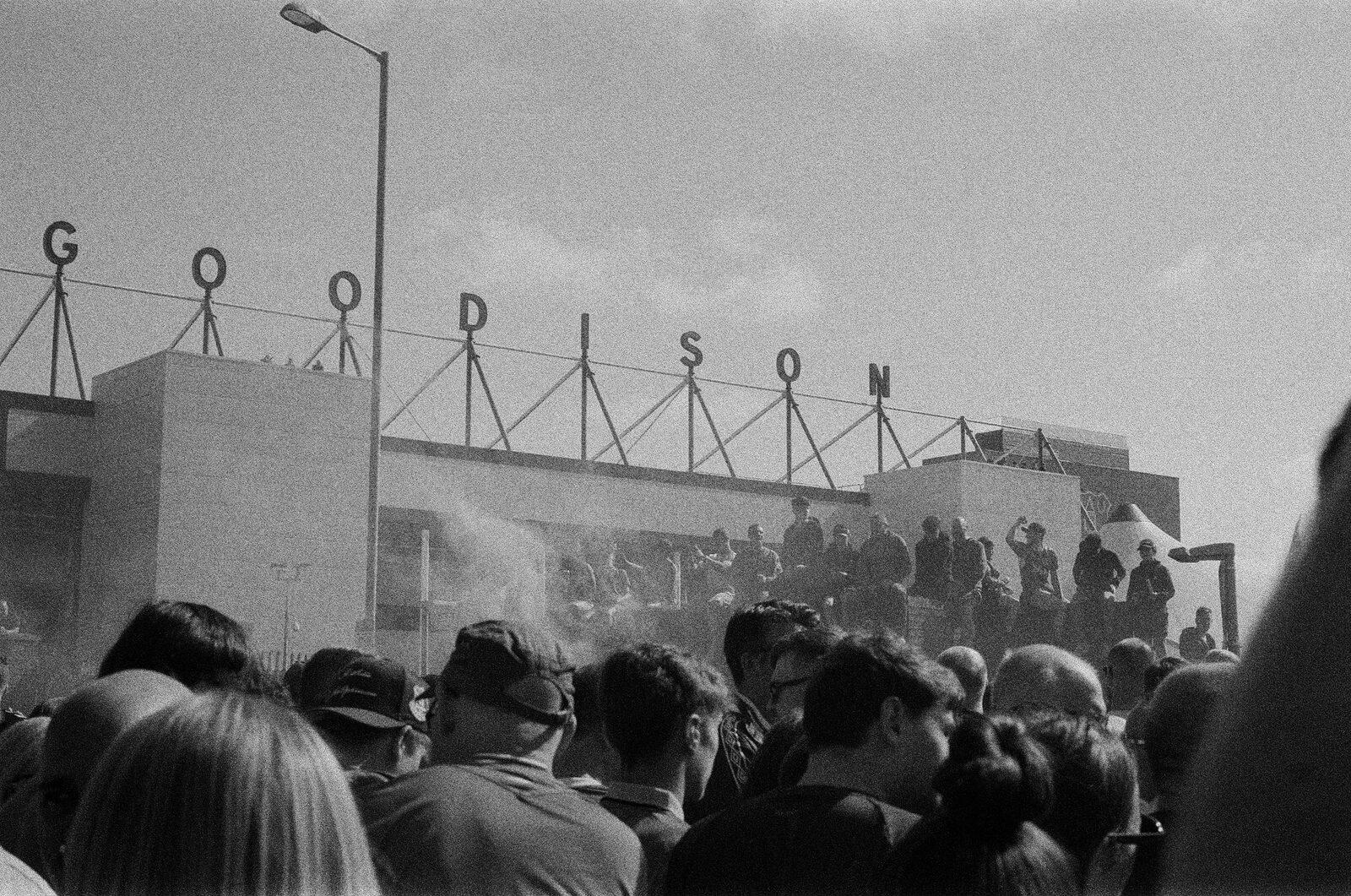 Fans gathered beneath the GOODISON letters on the stadium roof as flare smoke drifts past